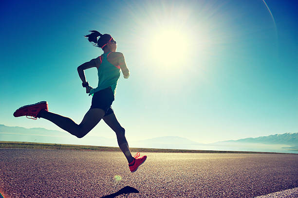 young fitness woman runner running on sunrise seaside trail